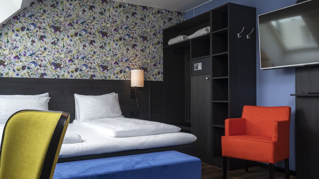 Säng och fåtölj i superior room på Thon Hotel Tromsø