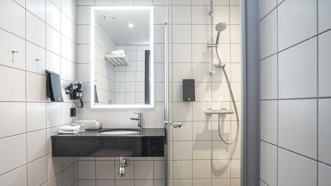 Dusch och handfat i badrummet i våra standardrum på Thon Hotel Tromsø