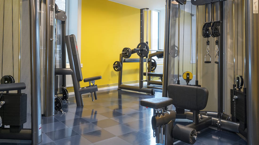 Fitness-rum Hotel Nidaros gule vægge med styrketræningsmaskiner