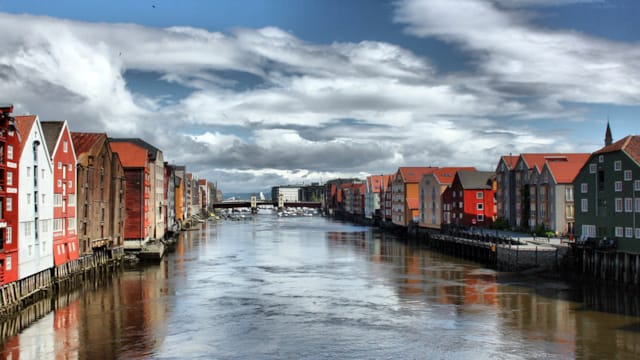 De stad Trondheim weeerspiegelt zich in de Nid-rivier (Nidelva)