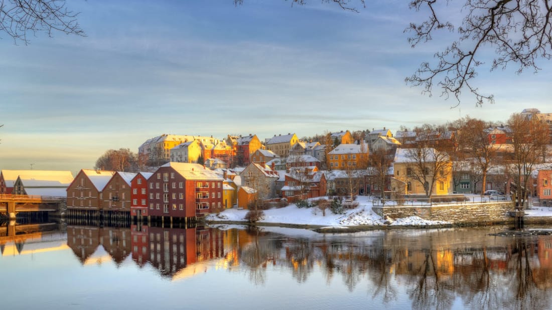 Trondheim på vinterstid som speiler seg i vannet