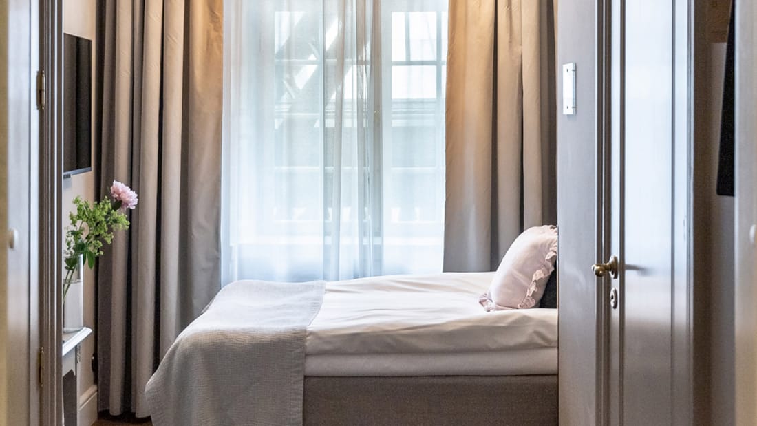 Säng framför fönster på Kungsträdgården Hotel, sedd från sidan