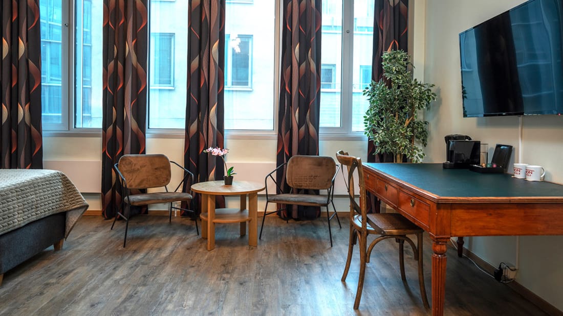 Skrivebord og siddegruppe foran vinduer i business-værelse på Thon Partner Hotel Kungsbron