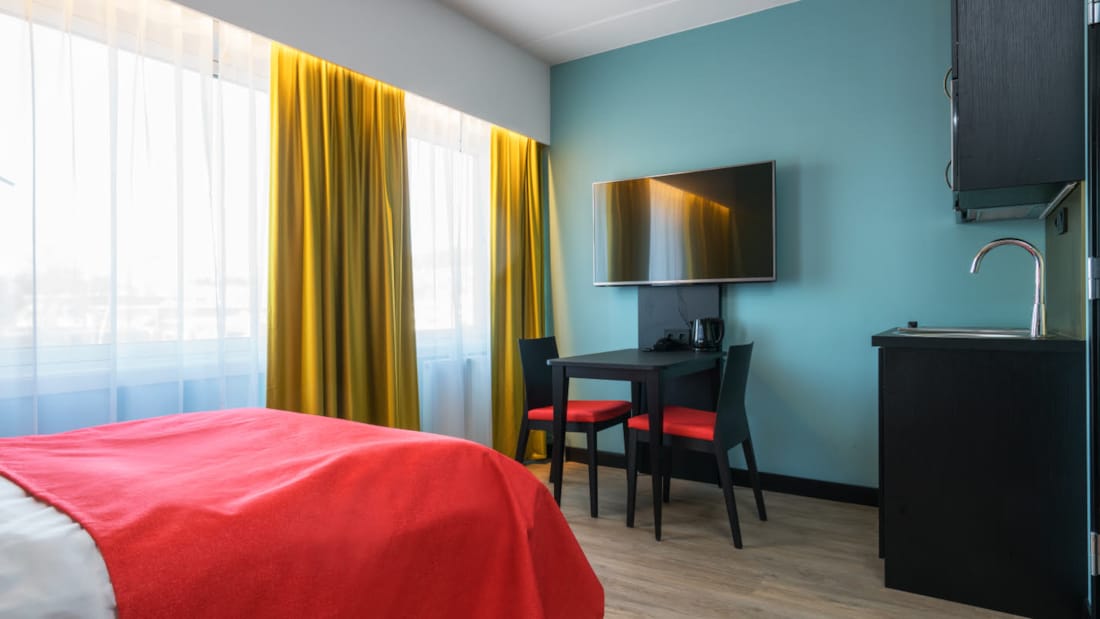 Lit double, téléviseur connecté et table de cuisine dans un appartement d’une chambre de Thon Hotel Linne Apartments