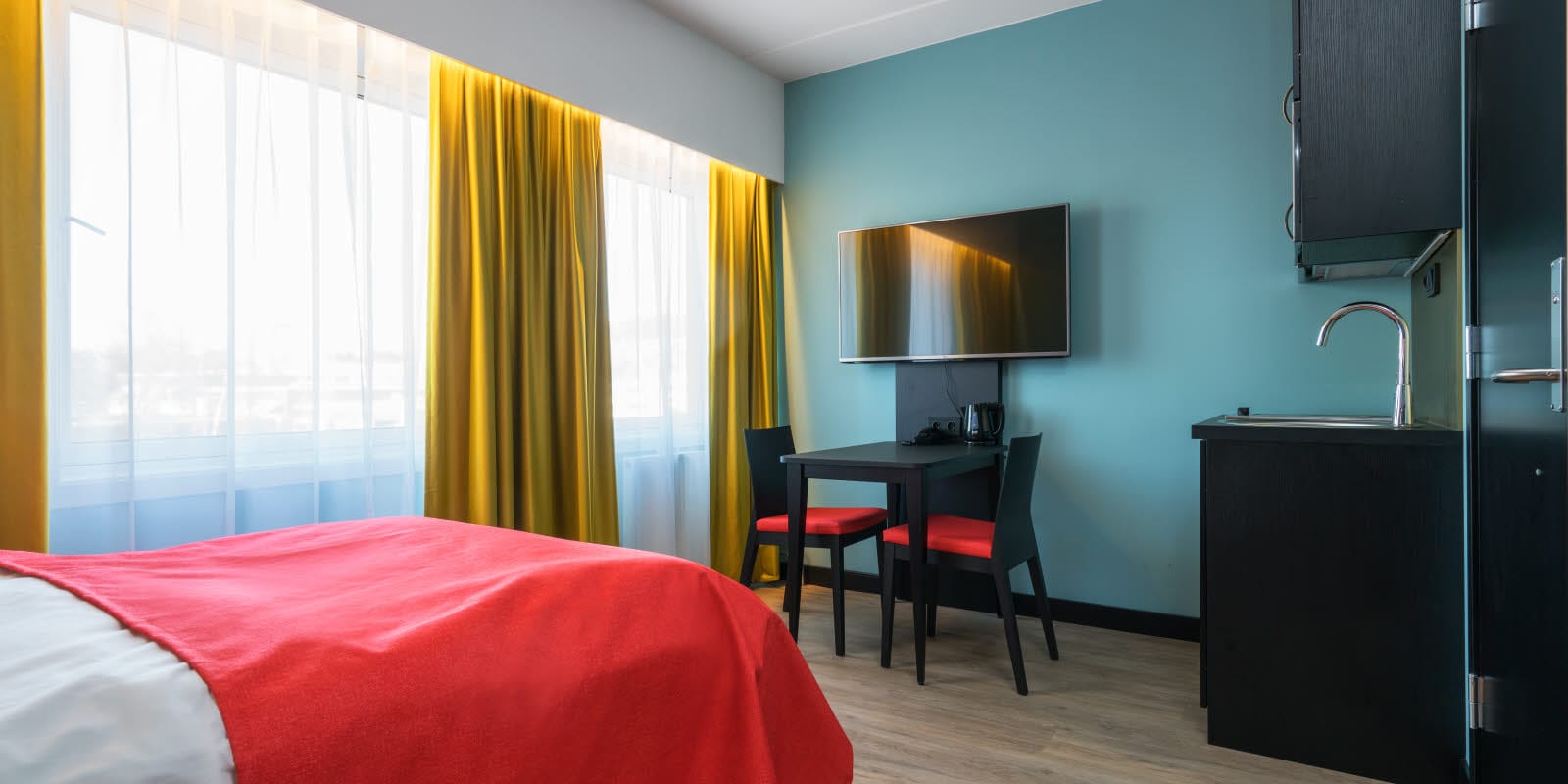 Doppelbett, Smart-TV und Küchentisch in einer 1-Zimmer-Wohnung im Thon Hotel Linne Apartments
