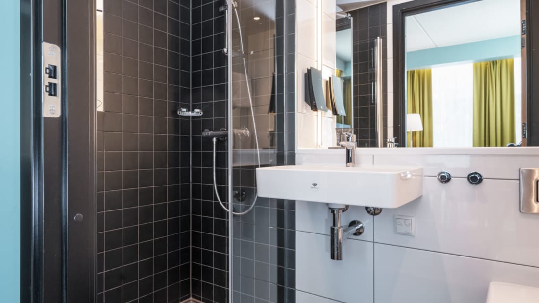 Badezimmer mit Dusche und Waschbecken im Thon Hotel Linne Apartments