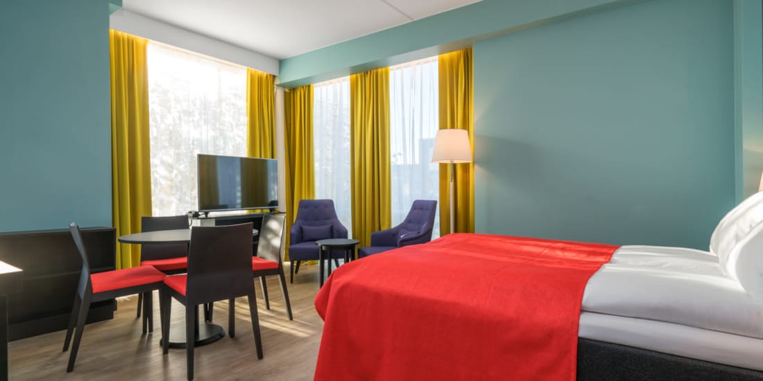 Tweepersoonsbed, smart-tv en keukentafel in tweepersoonsappartement van Thon Hotel Linne Apartments
