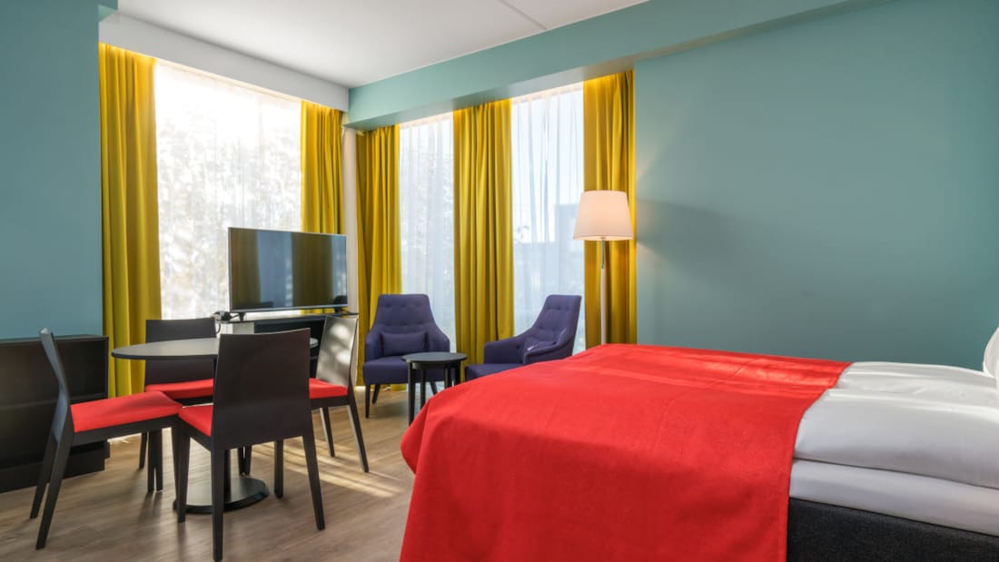 Doppelbett, Smart-TV und Küchentisch in einer 2-Zimmer-Wohnung im Thon Hotel Linne Apartments