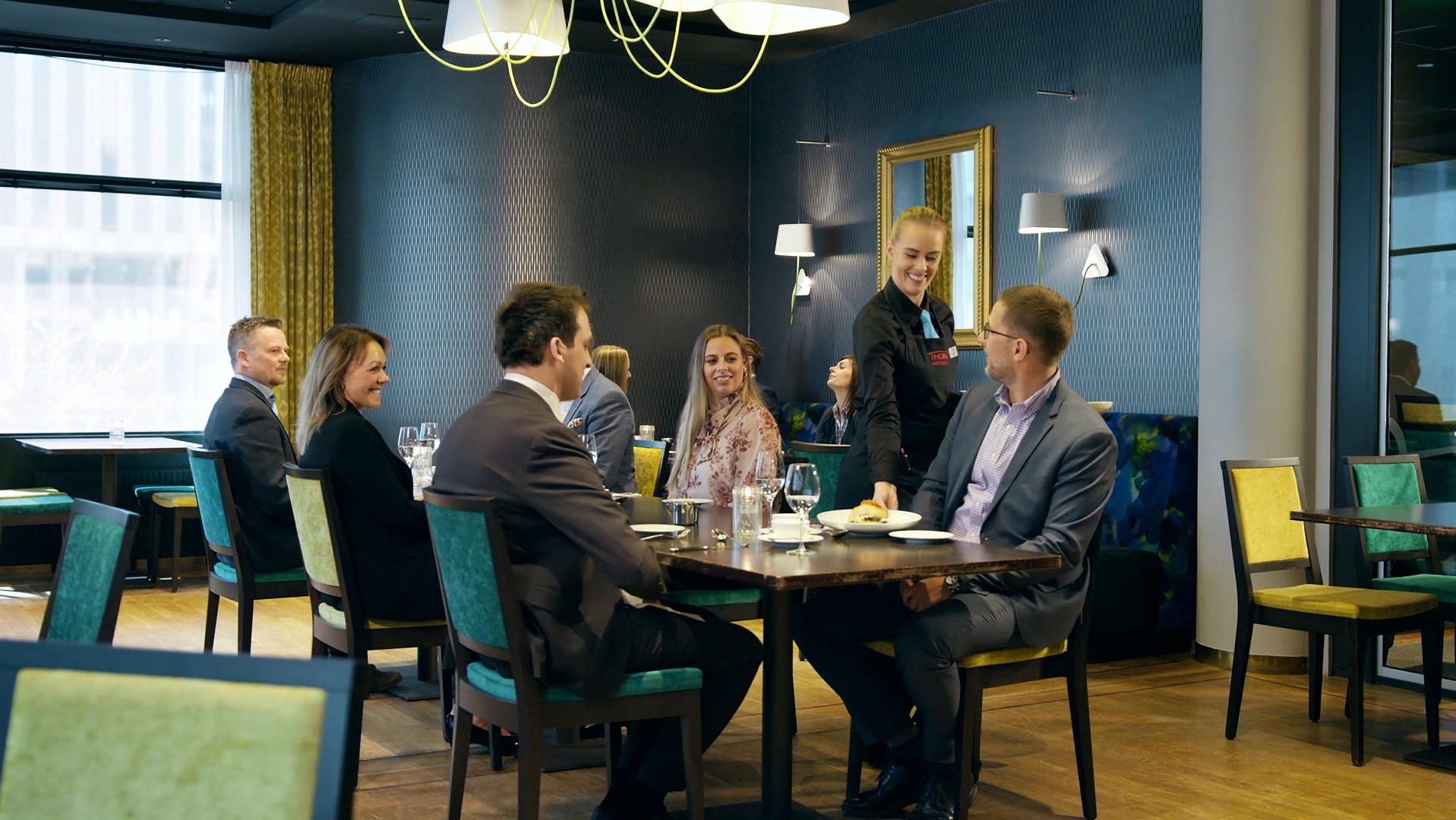 Eine Kellnerin bedient Kurs- und Konferenzgäste im Hotelrestaurant