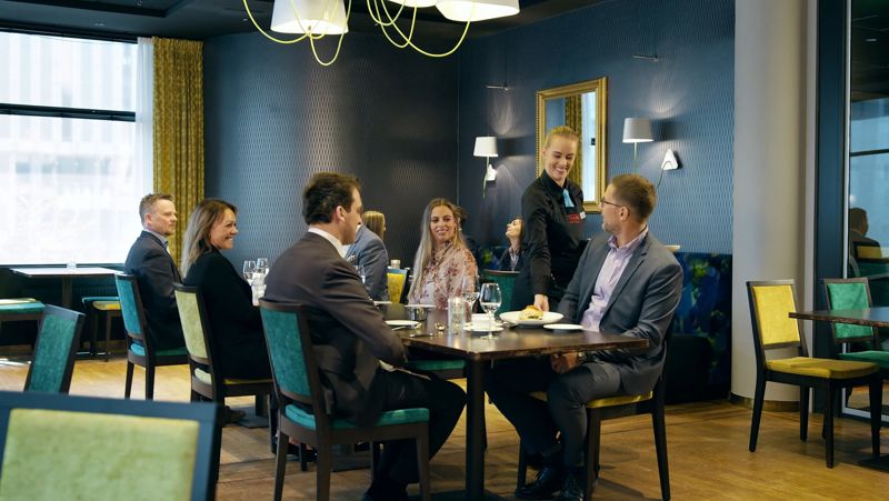 Ober bedient cursus- en conferentiegasten in het hotelrestaurant