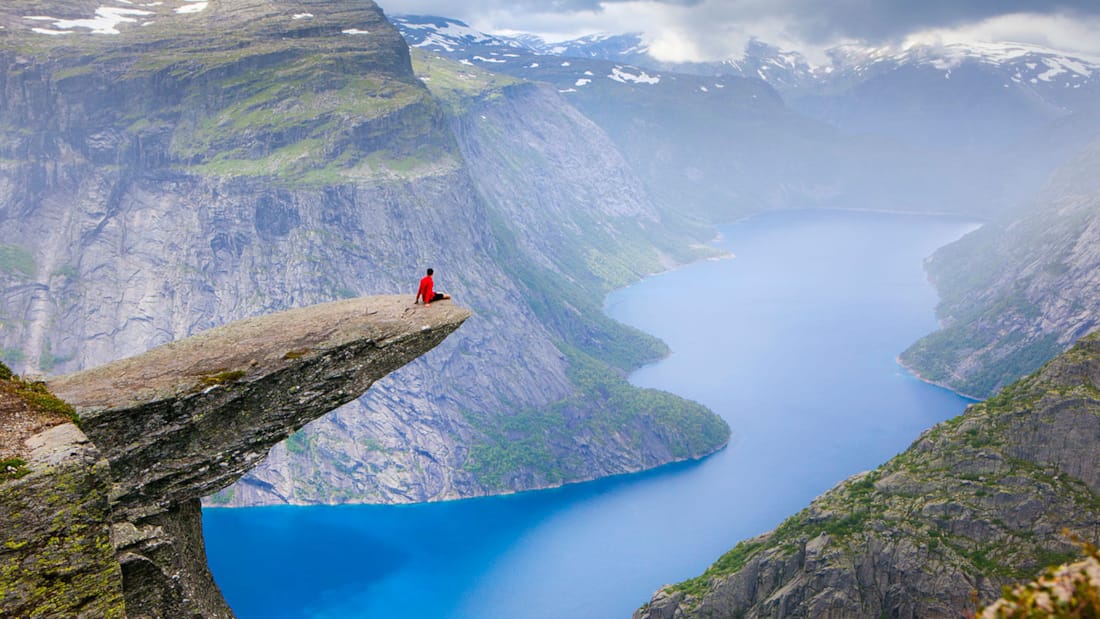 A person sitting at the far end of Trolltunga and enjoying the view