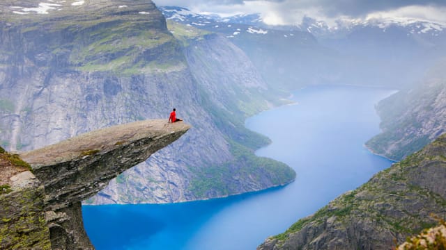 A person sitting at the far end of Trolltunga and enjoying the view