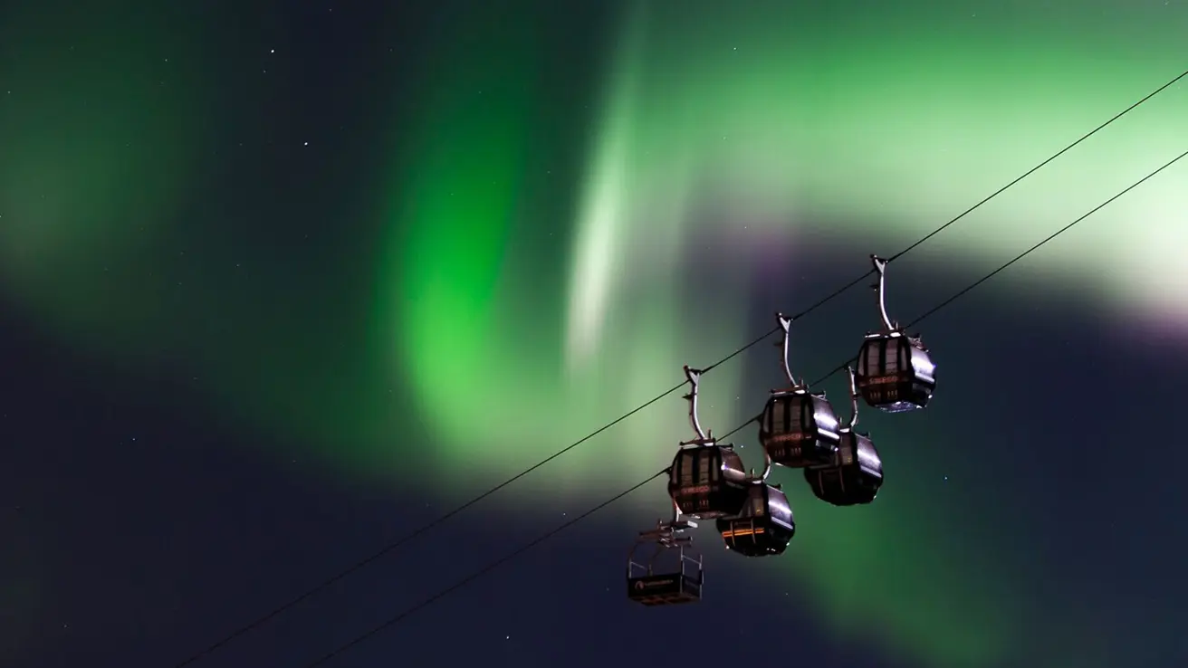 Nordlys som lyser opp himmelen over taubanen