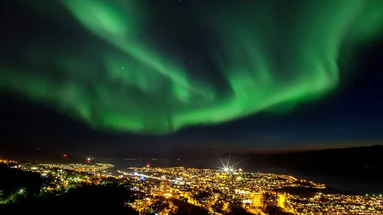 Foto Michael Ulriksen Noorderlicht boven de stad Narvik, die in het donker oplicht.