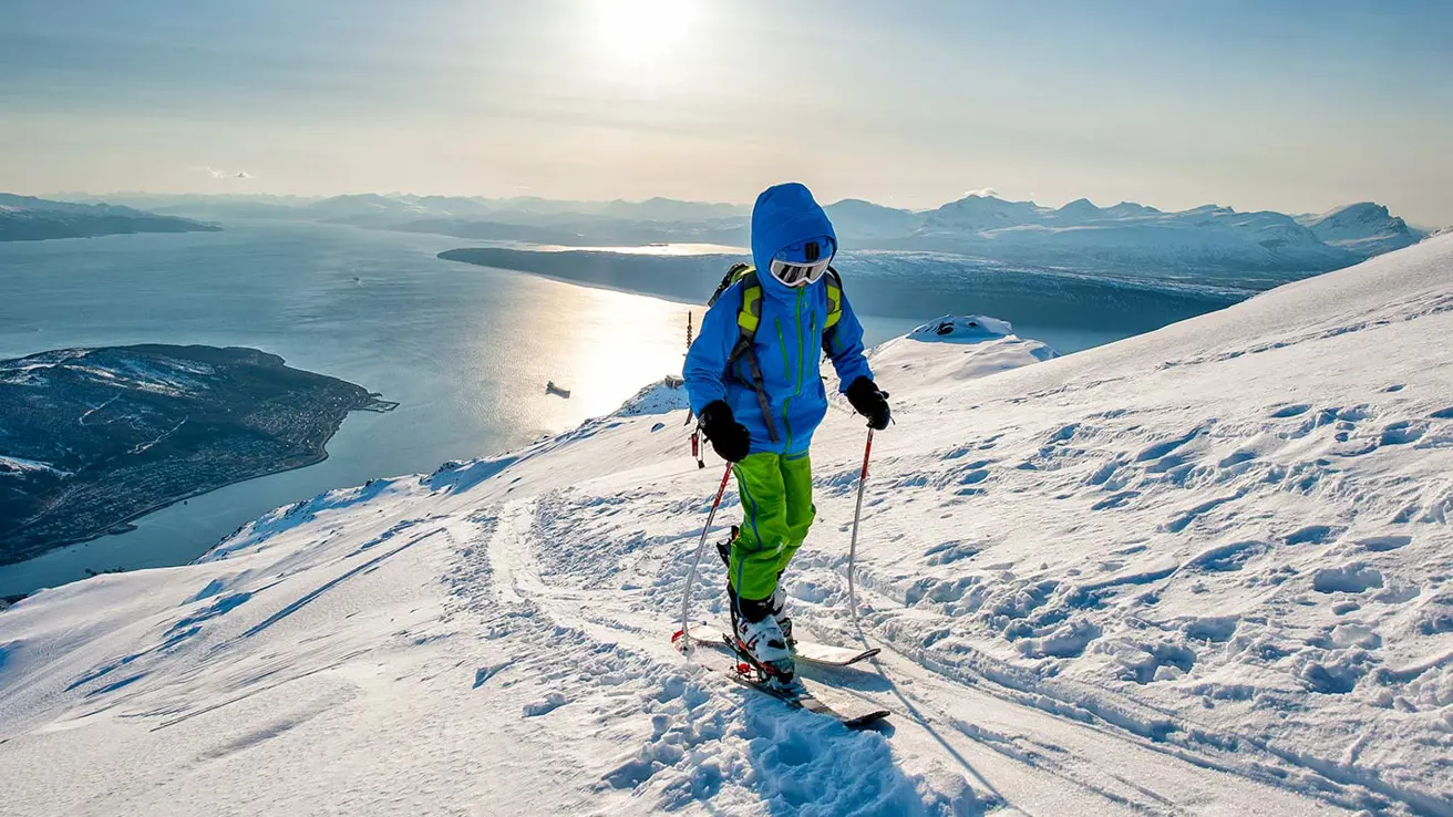 Foto Rune Dahl En person på ski står på toppen av et fjell.