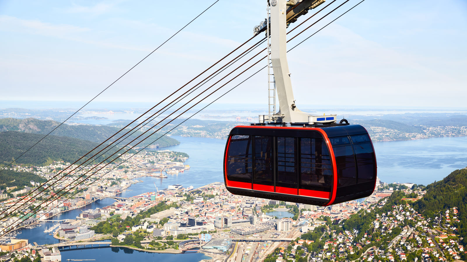 Red gondola on Ulriksbanen on its way up Ulriken. City of Bergen in background.