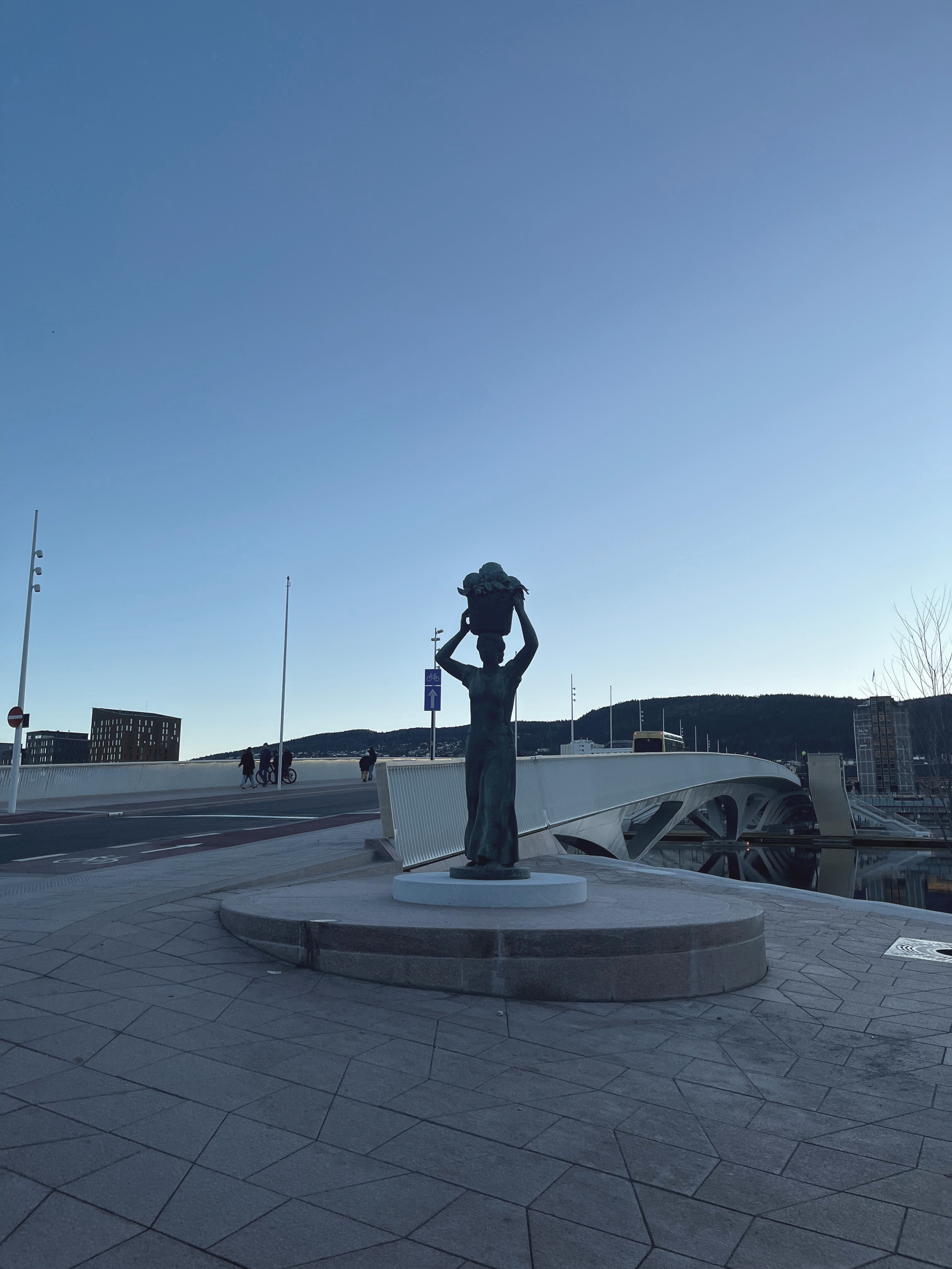 Statue av kvinne med kurv på hodet som står i enden av bybrua i Drammen.