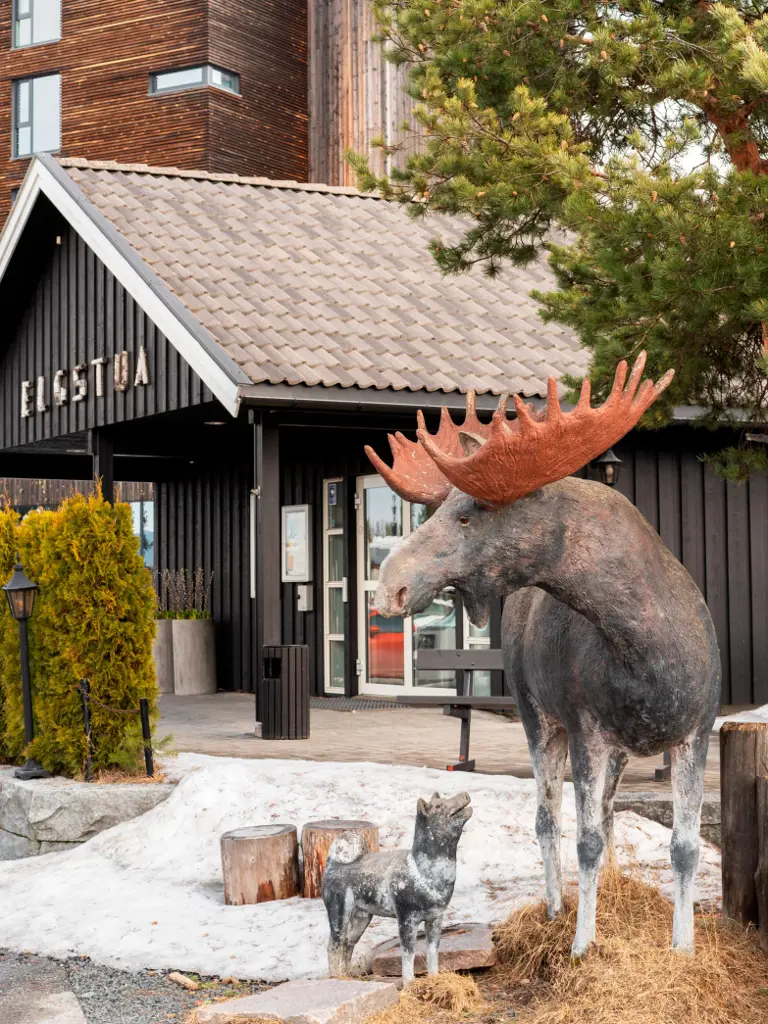 De ingang van Thon Partner Hotel Elgstua met een beeld van een eland rechts van de ingang.