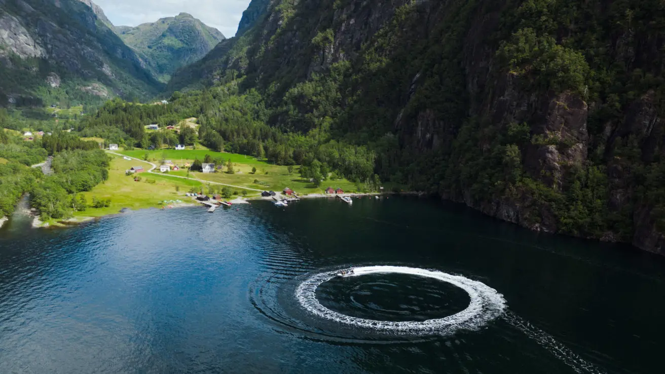 En RIB kjører i sirkel i Hardangerfjorden.