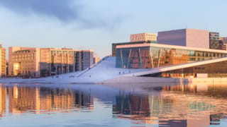 Aftenbillede af Operaen i Bjørvika, som du bør opleve, når du bor på hotel i Oslo.