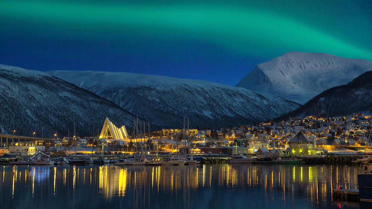 Nordlys som kaster lys over Tromsø by