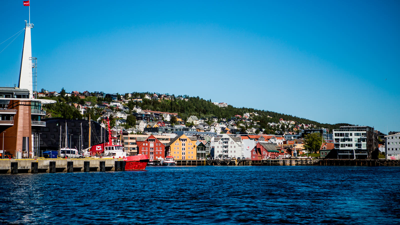 Vieux bâtiments en bois aux couleurs vives, qui abritent notamment le musée polaire, le long de l’eau à Tromsø.