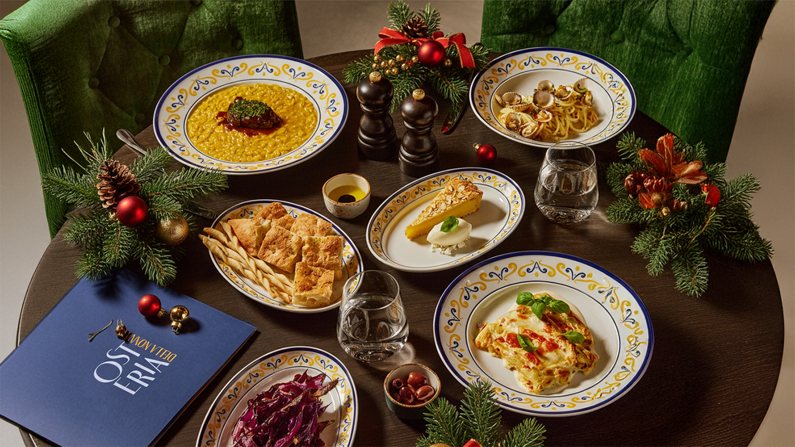 Forskjellige matretter på et bord med julepynt, sett overfra. 