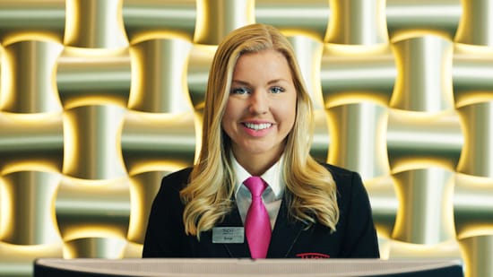 Receptionist i Thon Hotels reklamefilm, "Sæt kulør på dagen".