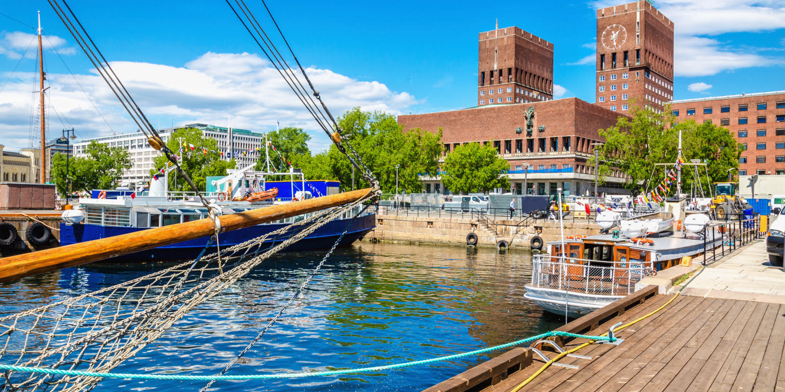 Het stadhuis van Oslo, met de Oslofjord op de voorgrond, op een zonnige dag.