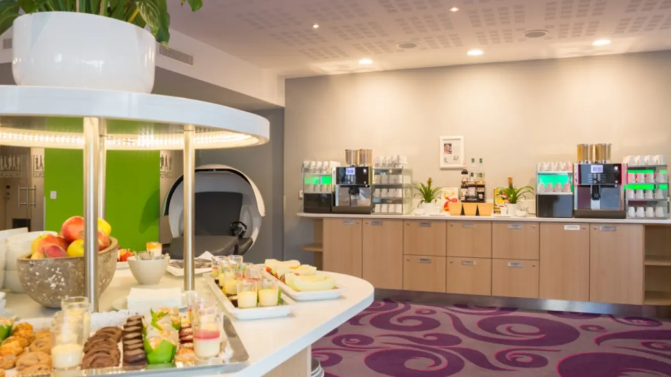 Farverigt pauseområde med kaffe, frugt og bagværk.