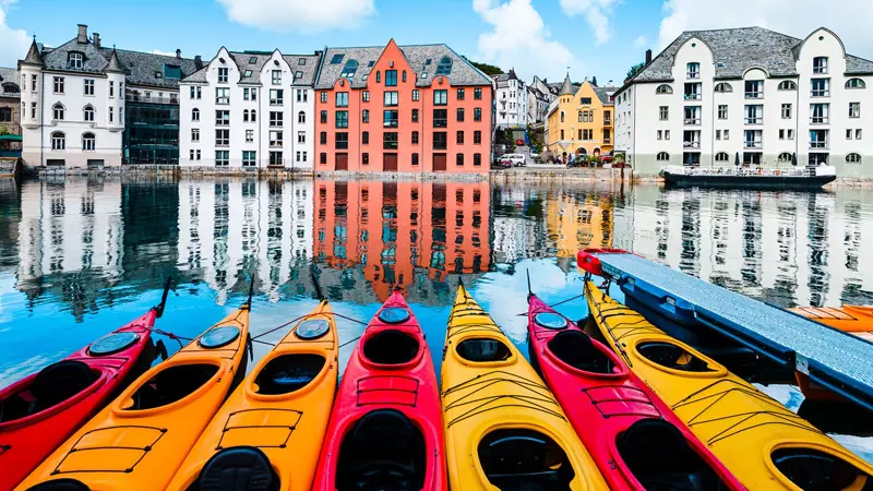 De nombreux kayaks à la queue leu leu dans l’eau au centre d’Ålesund