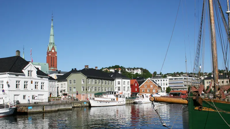 The Port of Arendal with houses and boats along the quayside