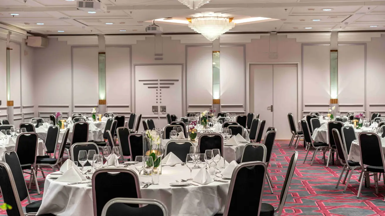 Großer Veranstaltungsort in Bankettanordnung mit Beleuchtung an den Wänden für Veranstaltungen